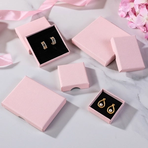 Elegant pink cardboard jewelry boxes with velvet sponges in multiple sizes on marble