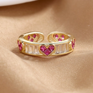 Adjustable gold plated ring with pink heart zircons on champagne satin background