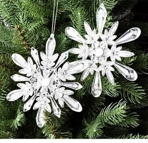 Gros plan de flocons de neige en acrylique transparent sur sapin de Noël vert
