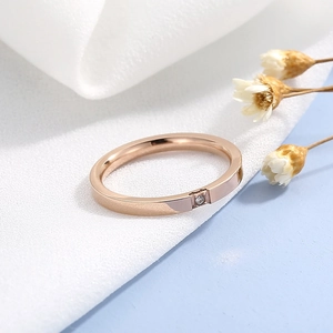 Détail macro de la bague minimaliste en acier inoxydable or rose avec un seul zircon