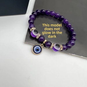 Detail showing purple crystal bead bracelet with Evil Eye charms and non-luminous finish