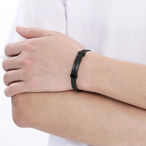 Macro detail of men's matte black stainless steel mesh bracelet with rectangular clasp