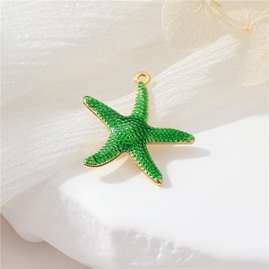 Close-up of green enamel starfish pendant with gold edges and grainy texture details
