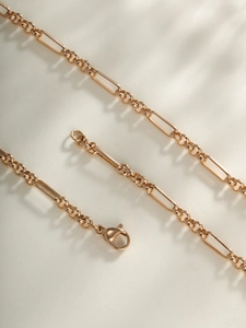 Detailed macro view of a gold-plated link chain necklace featuring a secure lobster clasp
