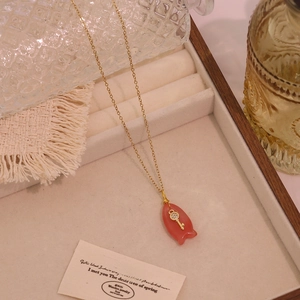 Detailansicht eines Fisch-Anhängers aus Naturstein mit Zirkonia-Schlüssel an Goldkette