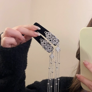 Detail of silver tassel hair clips with intricate Chinese knot design and metallic beads