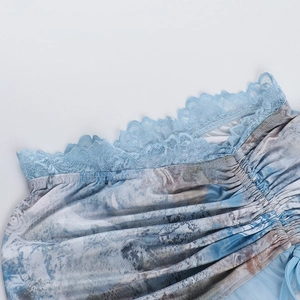 Detail of light blue lace trim and abstract print fabric with pleated texture