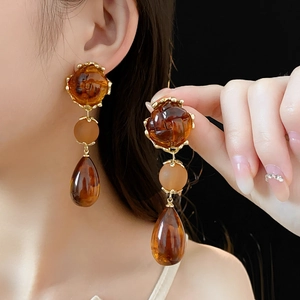 Detail of amber vintage drop earrings featuring faceted beads and teardrop resin pendants