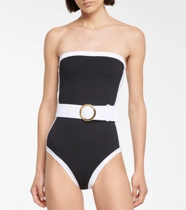 Detail of elegant black and white swimsuit with a gold buckle belt and textured fabric