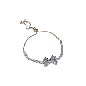 Sparkling silver bow bracelet with zircons and adjustable drawstring closure on white background