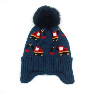 Detail of navy knit hat for kids with excavator pattern and soft faux fur pom-pom