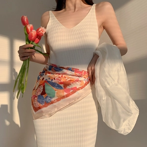 Chic white knit dress with a colorful paisley silk scarf in natural sunset lighting