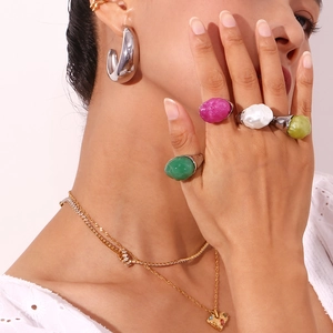 Detailed view of irregular green pink and white resin stones on stainless steel rings