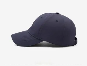 Detail view of the navy baseball cap featuring side NY embroidery and reinforced stitching