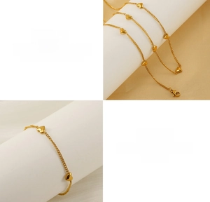 Detalle de conjunto de collar y pulsera de corazón en acero dorado sobre soporte blanco