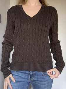 Détail d'un pull marron en maille torsadée avec col en V et texture douce et décontractée