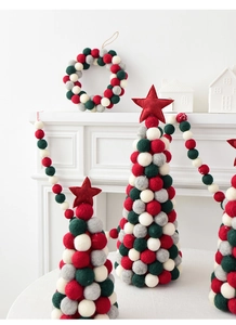 Christmas wool felt tree and wreath decor with colorful balls on a white fireplace