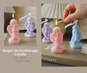 Close-up of angel scented candles in pink and blue with a lit wick and vintage decor