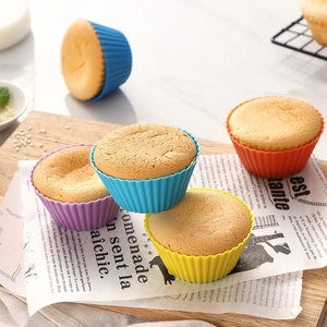 Close-up of colorful silicone muffin cups with freshly baked golden cupcakes on a tray