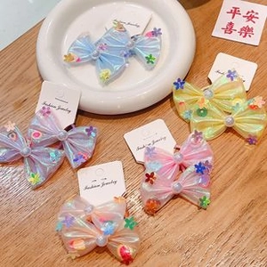Detail of moving butterfly hair clips with pearls and sequins in macaron colors