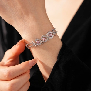Close-up of pink zircon geometric bracelet on wrist with silver chain detail