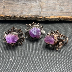 Detail of three vintage bronze rings with raw natural amethyst cluster stones