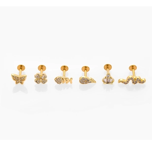 Close-up of gold stainless steel piercing set with crown, feather and animal motifs