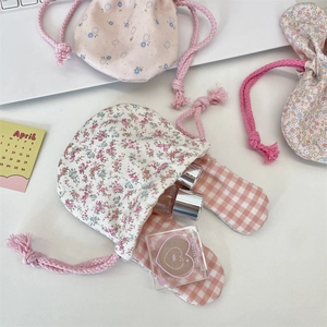 Detail of floral bunny ear drawstring bags with cotton textures for makeup storage