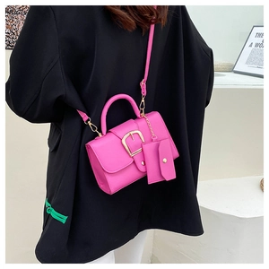 Detail of rose pink crossbody mini bag with litchi grain leather and gold buckle
