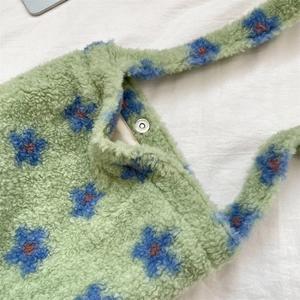 Close-up of the soft faux lamb wool texture and magnetic snap closure on a floral tote