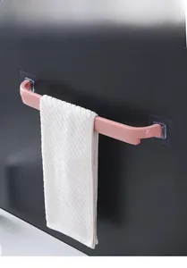 Pink wall-mounted bathroom towel bar with drill-free adhesive design and a white towel