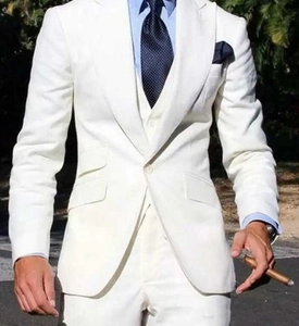 Detail view of men's white three-piece suit including blazer, vest, and trousers outdoors