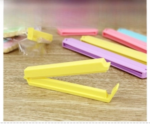 Long candy-colored food sealing clip on wooden surface for moisture-proof freshness