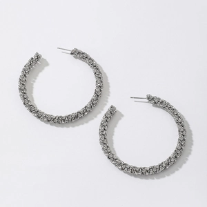 Detailed view of silver hoop earrings with shimmering rhinestones on white background