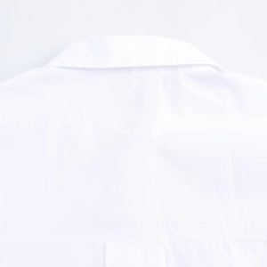 Detailed view of the lapel collar and cotton fabric texture on a white long-sleeve shirt