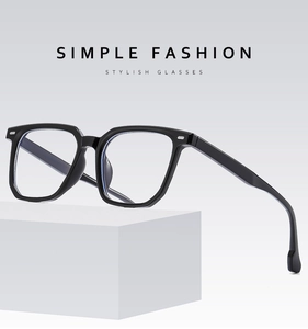 Detail of minimalist black full-frame glasses on a clean white geometric platform