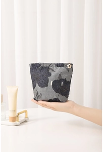 Close-up of floral jacquard fabric and small flower pendant on the makeup pouch
