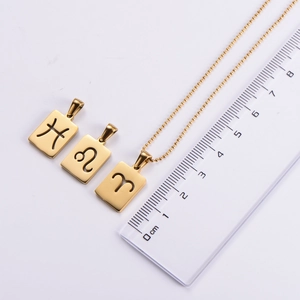 Golden zodiac pendant size comparison with ruler showing precise dimensions