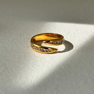 18k gold plated open ring with shimmering zircon accents on a textured background