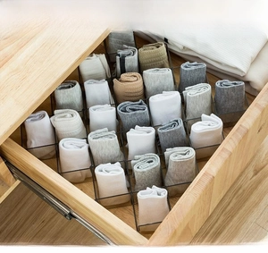 DIY black metal drawer dividers showing customizable grid setup in a wooden closet