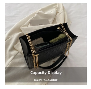 Top view of spacious interior of black quilted tote bag with gold chain strap