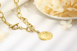 Close-up of gold Virgin Mary coin pendant with T-bar clasp on stainless steel chain