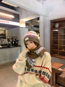 Close-up of Fair Isle knit beanie and scarf set with geometric patterns in cozy cafe