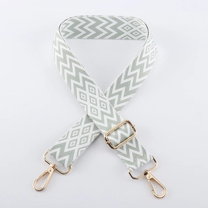 Detail of adjustable green and white embroidered chevron strap with gold metal hardware