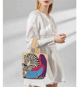 Detail of beige tote bag featuring artistic zebra print and colorful wing patterns