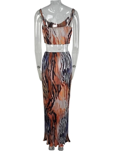 Rear view of pleated two-piece set with abstract print featuring a cropped top and long skirt