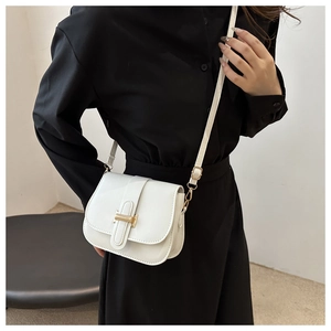 Detail of white saddle crossbody bag with golden H-lock clasp and adjustable strap