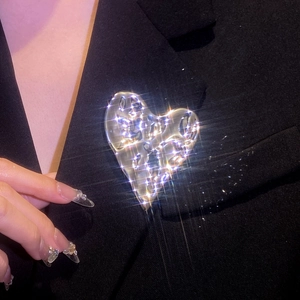 Broche cœur irrégulière en argent liquide épinglée sur le revers d'un costume noir
