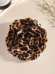 Detailed top view of a fabric leopard print rose brooch featuring mesh petals on a desk