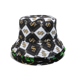 Détail d'un chapeau bob montrant des motifs de dollars dorés et de chaînes sur toile